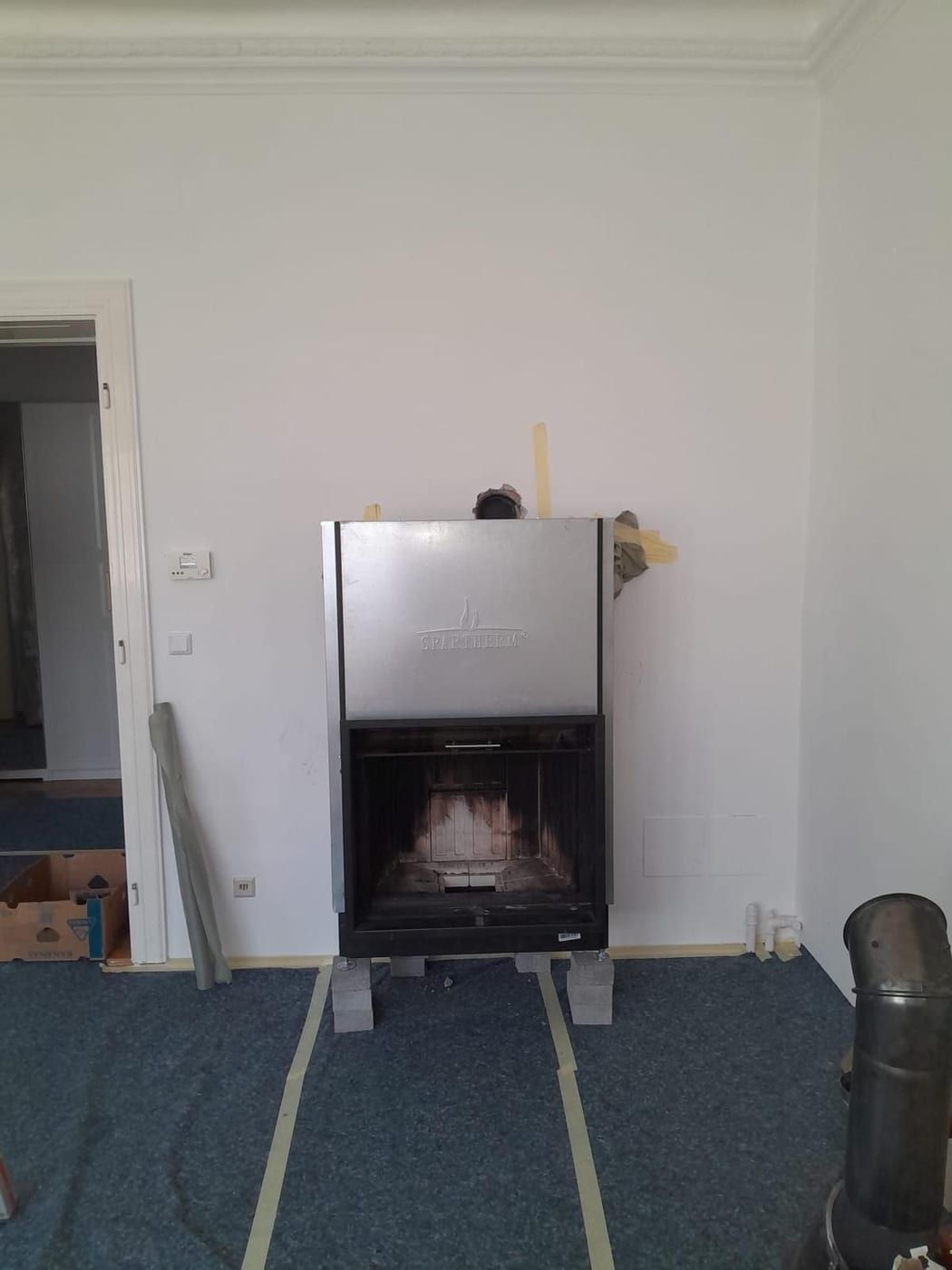 Frei stehender Heizeinsatz auf Betonsteinen vor der Verkleidung im Altbau
