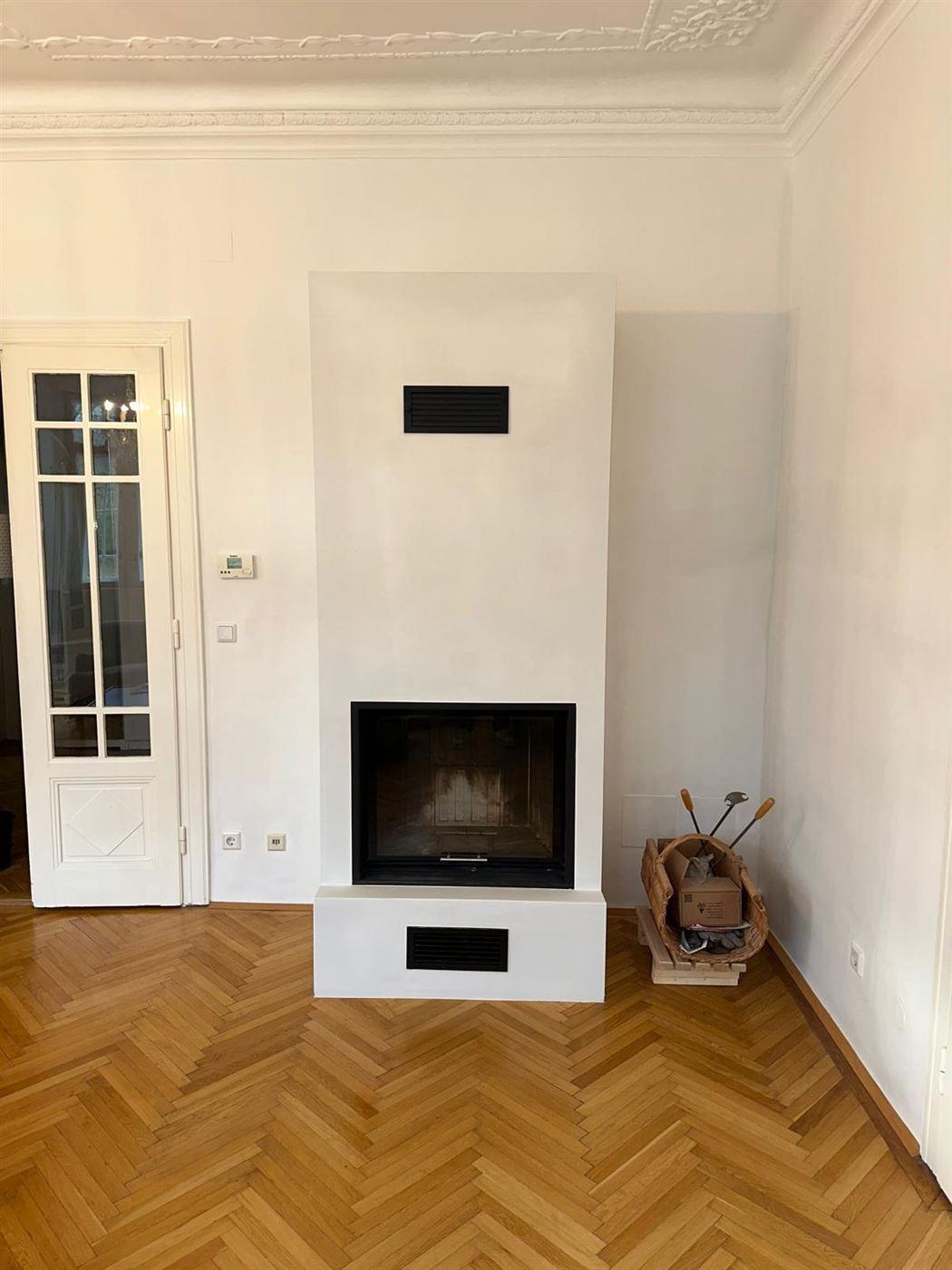 Fertiger weißer Heizkamin unter der Stuckdecke im Wiener Altbau