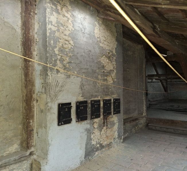 Wangenmauer mit abbröckelndem Altputz und offenen Stellen vor der Sanierung