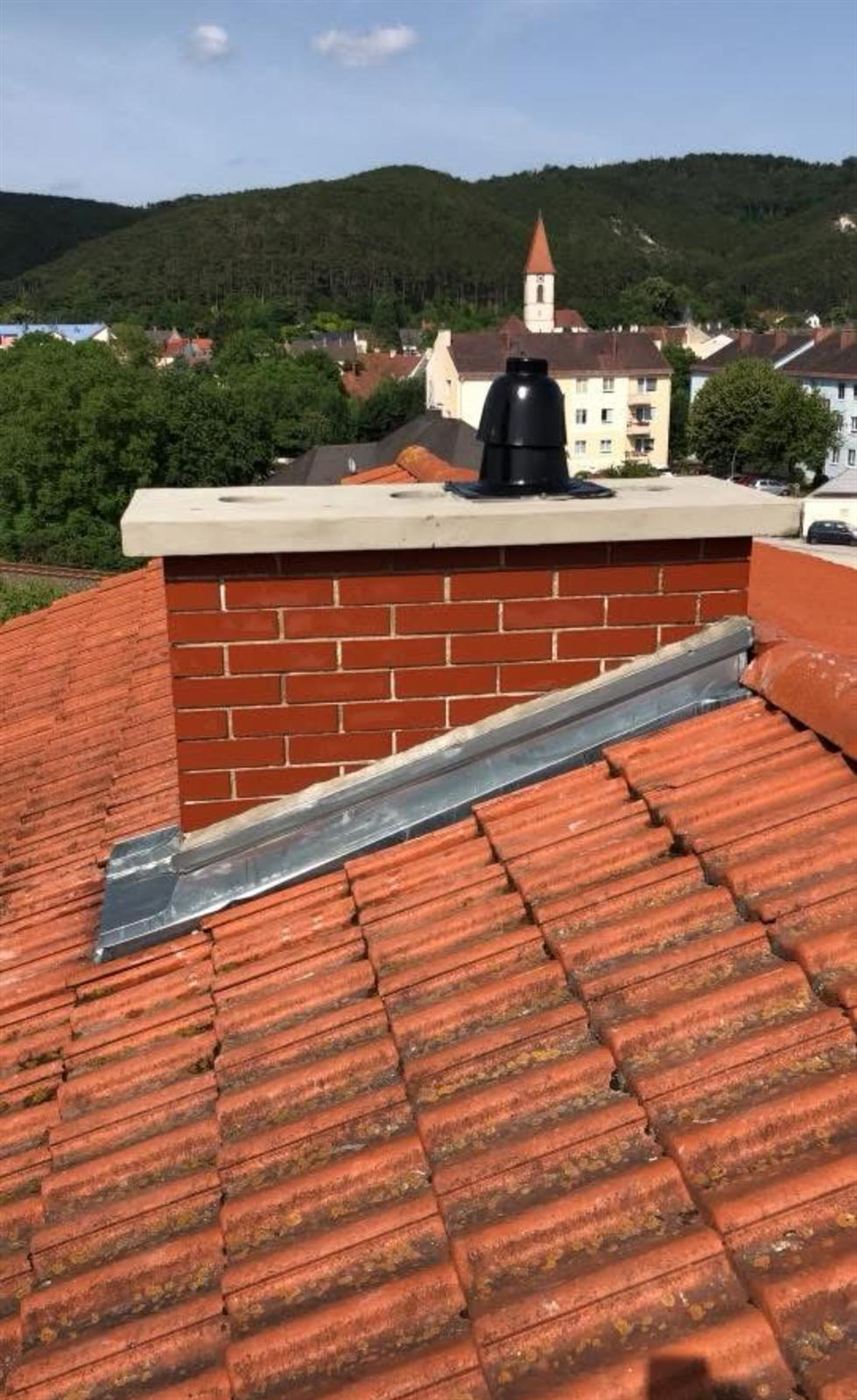 Neuer gemauerter Kaminkopf mit Betonabdeckplatte und Kaminaufsatz