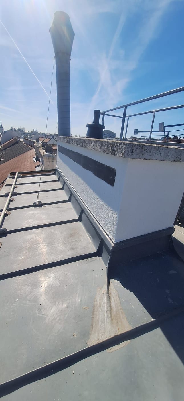Kaminkopf während der Sanierung mit frisch gespachtelter Kleberzone unter der Abdeckplatte