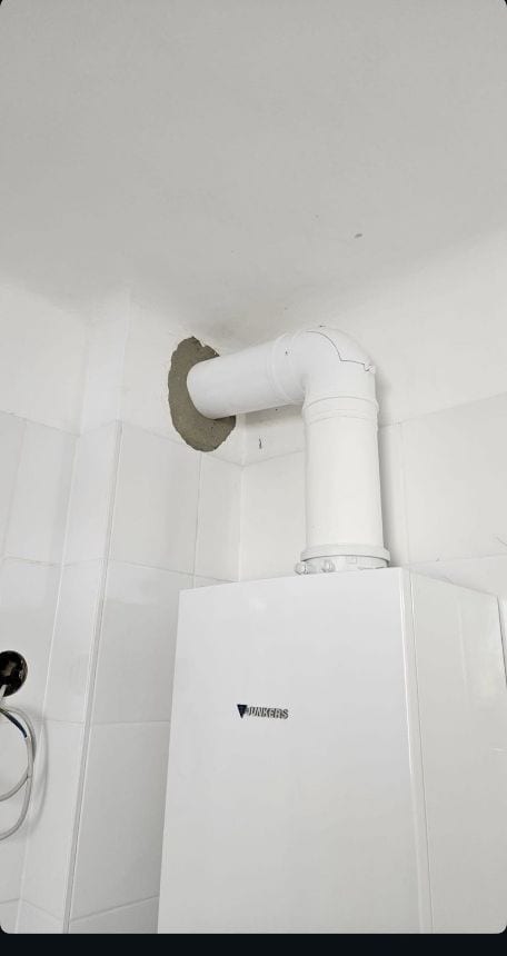 Brennwerttherme mit neuem Abgasrohr durch die Kernbohrung in den Kaminzug