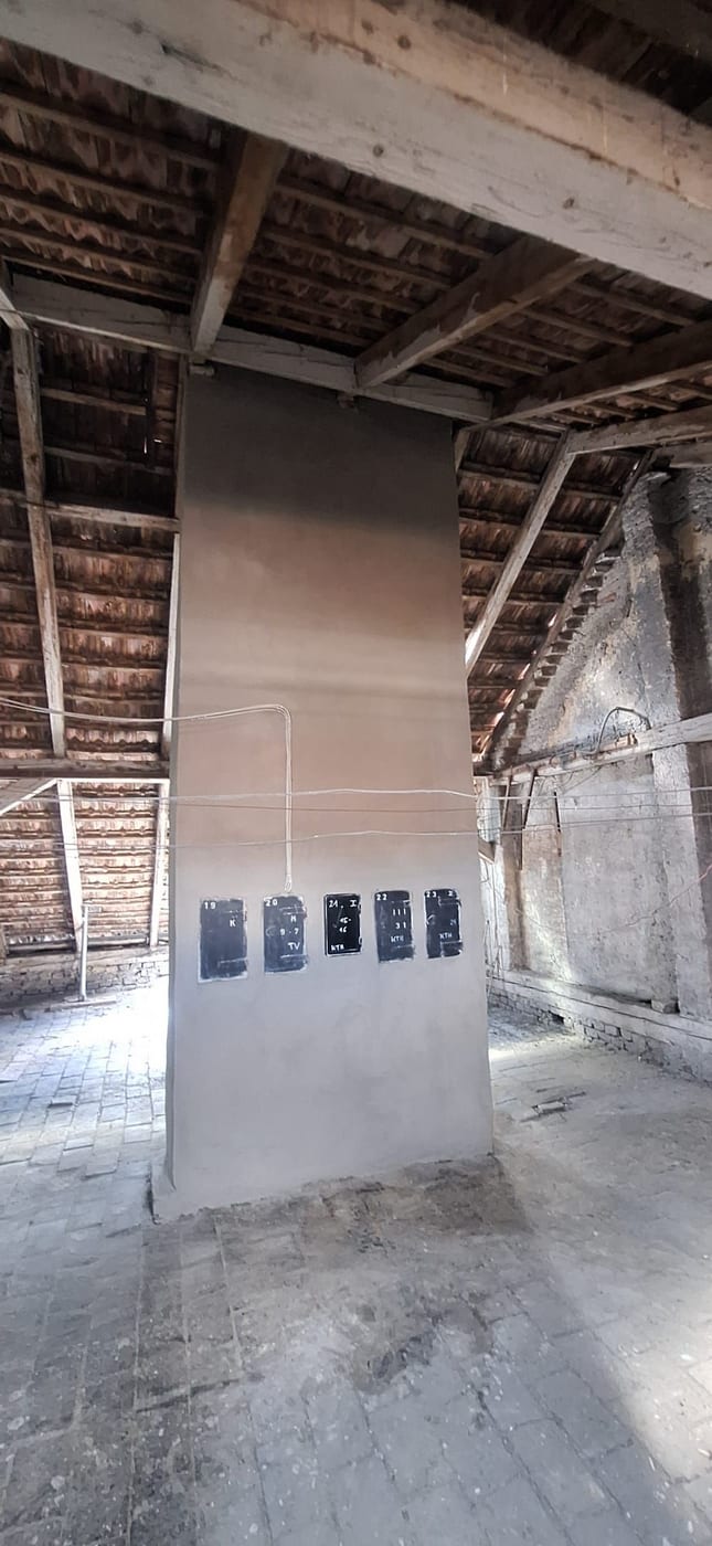 Frisch verputzte Wangenmauer mit neuen Kehrtüren im Dachboden