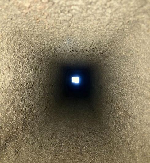 Glatt ausgeschliffener Kaminzug mit Tageslicht am Schachtende