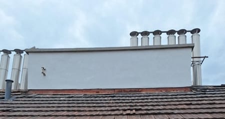 Derselbe Kaminkopf mit glattem weißem Silikatputz nach der Sanierung
